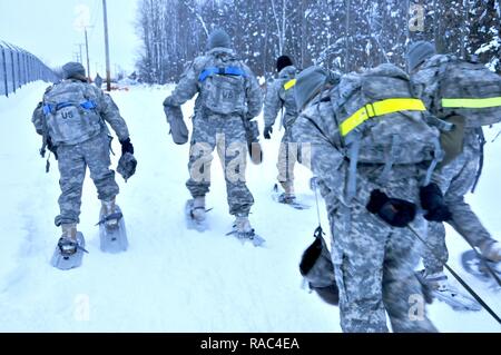 Soldaten aus dem 10. Zentrale und speziellen Truppen Bataillon konkurrieren in einer Schneeschuhwanderung Herausforderung während PT mit der US Army Forces Command Sgt. Maj. in Fort Drum Licht Kämpfer Schule am 10. Januar 2017. Die ungefähre 3 Meile Kurs müssen Teams zusammenarbeiten, um Munition und Würfe zu tragen und zusätzliche Herausforderungen wie ein 100 m kettlebell werfen. Stockfoto