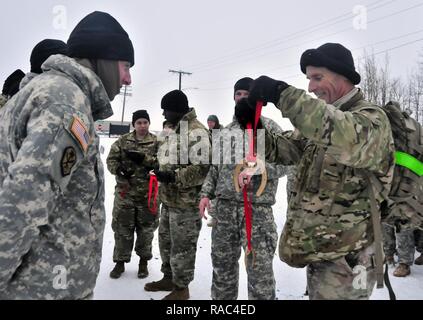 Us Army Forces Command Sgt. Maj. Scott Schroeder Auszeichnungen, Medaillen zu gewinnen Fireteam aus einer Schneeschuhwanderung Herausforderung am Fort Drum Licht Kämpfer Schule am 10. Januar 2017. Die ausgezeichneten Soldaten gegen andere Mannschaften, die über ihre Bataillon in einem 3 Meile Schneeschuh Herausforderung, einschließlich Munition trägt konkurrierten, Wurf zieht und Ein kettlebell werfen. Stockfoto