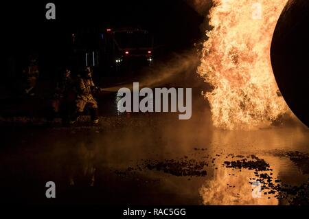 Feuerwehrmänner vom 23 d Bauingenieur Geschwader team Flammen während der Nacht, Live Fire Training, Jan. 10, 2017 zu löschen, bei Moody Air Force Base, Ga die Turboprop-maschinen Brände wurden durch Propangas Assistant Chief des Feuerwehr Training, Charlie Johnson. Stockfoto