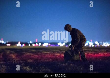 Ein US-Marine Form der 3 Reconnaissance Bataillon, 3rd Marine Division, III Marine Expeditionary Force erholt sich ein Fallschirm nach der Landung am Yokota Air Base, Japan, Jan. 11, 2017, während der Woche springen. Die Ausbildung nicht nur erlaubt, die Marines zu springen üben, aber es ist auch erlaubt, die yokota Besatzungen Flug Taktiken zu üben und timed-Paket fällt. Stockfoto