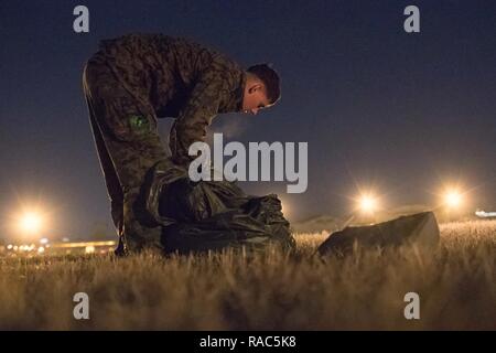 Ein US-Marine Form der 3 Reconnaissance Bataillon, 3rd Marine Division, III Marine Expeditionary Force erholt sich ein Fallschirm nach der Landung am Yokota Air Base, Japan, Jan. 11, 2017, während der Woche springen. Die Ausbildung nicht nur erlaubt, die Marines zu springen üben, aber es ist auch erlaubt, die yokota Besatzungen Flug Taktiken zu üben und timed-Paket fällt. Stockfoto