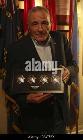 Oberstleutnant Kenneth Leitungen, einem US-Marine Veteran, erhält ein Andenken seiner Zeit als Reserve stellvertretender während seiner Pensionierung Zeremonie von der Abteilung des Sheriffs in San Diego, Calif., Jan. 12, 2017 zu Ehren. Die Memento ist ein Schatten Box mit vier Sheriff Abzeichen. Rohre zuerst im 1. Marine Division mit dem zweiten Bataillon, 7. Marine Regiment. Rohre diente 25 Jahre lang in der United States Marine Corps und 26 Jahre in der San Diego Sheriff Department Reserven, die während der Kuba-krise und Vietnam Krieg mit der 1. Marine Division enthalten. Stockfoto