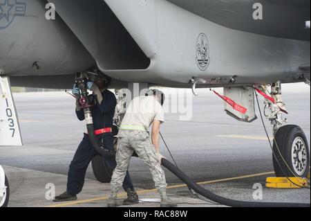 Us Air Force Senior Airman Marcus Leonard, Links, 18 Aircraft Maintenance Squadron Crew Chief und Airman 1st Class Moises Leos, rechts, 18 Logistik Bereitschaft Squadron Brennstoffe Verteilung operator, Auftanken, eine F-15 Eagle während surge Operationen Jan. 11, 2017, bei Kadena Air Base, Japan. Während dieser speziellen Überspannungsschutz, der 67Th Fighter Squadron überschritten ihre sortie Ziele für den angegebenen Zeitraum. Stockfoto