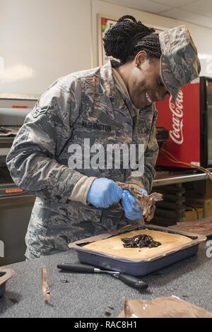 Us Air Force Airman 1st Class Ambrasia Washington aus die 116. Air Control Wing (ACW) Leistungen Flug, Georgia Air National Guard (ANG), ICES-Kuchen beim Abendessen Vorbereitung für gemeinsame - Kräfte Personal zur Unterstützung der 58 Präsidentschafts-einweihung, Washington, D.C., 18. Januar 2017. Ein Team von 10 Fliegern aus dem 116 ACW implementiert mit Ihren Disaster Relief Mobile Küche Anhänger (DRMKT). Arbeiten von FedEx Field, der Heimat der Washington Redskins, arbeitete das Team an der Seite von Services Teams aus anderen ANG Einheiten über der Nation vorbereiten und servieren zu über 3.500 Joint Force Mitglieder pe Stockfoto