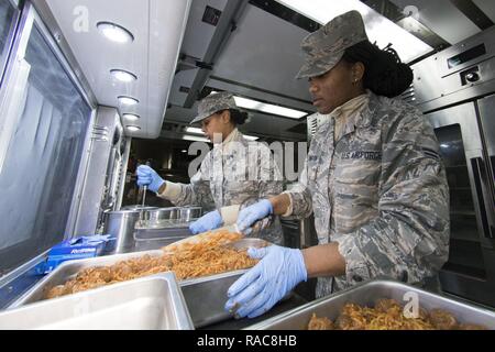 Us Air Force Airman 1st Class Ambrasia Washington, rechts, und Kayla Akers aus die 116. Air Control Wing (ACW) Leistungen Flug, Georgia Air National Guard (ANG), Schalen von Spaghetti beim Abendessen Vorbereitung für gemeinsame - Kräfte Personal zur Unterstützung der 58 Präsidentschafts-einweihung, Washington, D.C., 18. Januar 2017 vorzubereiten. Ein Team von 10 Fliegern aus dem 116 ACW implementiert mit Ihren Disaster Relief Mobile Küche Anhänger (DRMKT). Arbeiten von FedEx Field, der Heimat der Washington Redskins, arbeitete das Team an der Seite von Services Teams aus anderen ANG Einheiten über der Nation vorbereiten und mich mit Stockfoto