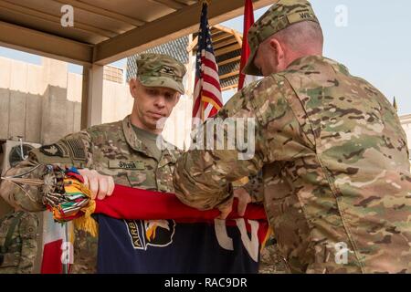 Us-Armee Oberst Brett Sylvia (links), Commander, 2nd Brigade Combat Team, Luftlandedivision - Air Assault und U.S. Army Command Sgt. Maj. Jason Wilson, 2 BCT, 101 Abn. Div. - Air Assault, Fall die Brigade Farben bei einer Übertragung der Autorität Zeremonie in Bagdad, Irak, Jan. 19, 2017. Die Zeremonie abgeschlossen eine neun-Monats-Bereitstellung für den Streik Bde., bei der es um wichtige beraten und unterstützen, um die irakischen Sicherheitskräfte unterstützen als Teil des kombinierten Joint Forces Land Component Command's multi-nationale Koalition Unterstützung der Combined Joint Task Force - inhärenten Lösen zur Verfügung gestellt Stockfoto