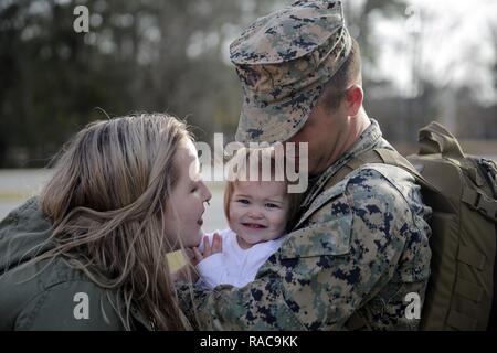 Ein US-Marine mit speziellen Zweck Marine Air-Ground Task Force Krise Response-Africa ist die Heimat von seiner Familie aufgenommen, als er in Camp Lejeune, N.C., Jan 17, 2017 zurück. Während der neun-Monats-Bereitstellung, Marinesoldaten und Matrosen dienten als Logistik combat Element für Operationen und Übungen in ganz Europa und Afrika. Us-Marines und Matrosen zu speziellen Zweck Marine Air-Ground Task Force-Crisis Response-Africa Befehl Support Operations, unvorhergesehene Ereignisse und die Zusammenarbeit im Bereich der Sicherheit in den USA Africa Command Verantwortungsbereich zugeordnet. Stockfoto