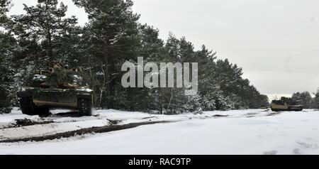 M1 Abrams Panzer entstehen aus bewaldeten Gelände nach Soldaten auf das erste Bataillon zugeordnet, 68th Panzer Regiment, 3. gepanzerte Brigade, 4 Infanterie Division verdeckte sie mit der Umgebung zu verschmelzen, Jan 20, 2017 Presidential Range in Swietozow, Polen. Die Fahrzeuge und Soldaten in Polen letzte Woche von Colorado Springs, Colorado kamen im Rahmen eines neunmonatigen Einsatz zur Unterstützung der Operation Atlantic lösen. Diese Drehung wird Abschreckung Fähigkeiten in der Region verbessern, verbessern die US-Fähigkeit, potenzielle Krisen zu reagieren und Verbündete und Partner in der Europea verteidigen. Stockfoto