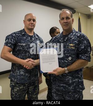 MARINE CORPS BASE HAWAII - Hinten Adm. John Weigold, der stellvertretende Kommandeur der US-Pazifikflotte, präsentiert eine militärische Herausragende ehrenamtliche Service Medal zu Petty Officer 1st Class Brandon Thompson, eine Crew Chief mit Fleet Logistics Support Squadron 51, und ein Eingeborener von Bonners Ferry, Idaho, während einer Preisverleihung im Hangar 5 statt an Bord der Marine Corps Air Station Kaneohe Bay, Marine Corps Base Hawaii, am 18.01.2017. Weigold besucht VR-51 im Zuge der Insel Tour der Reserve der Marine Einheiten, in denen er sich mit Seeleuten unterhielt, treffen die Männer und Frauen unter seinem Kommando. Stockfoto