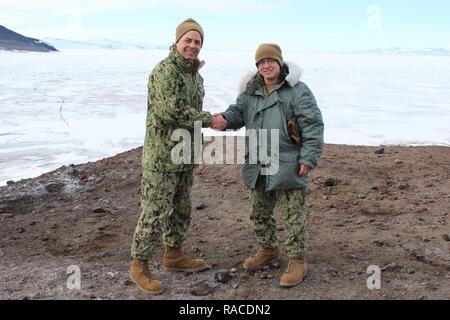 CDR Melvey, Kommandierender Offizier der Marine Cargo Handling Bataillon, reenlisted und gratuliert einem Sailor NCHB-1 zugewiesen. Stockfoto