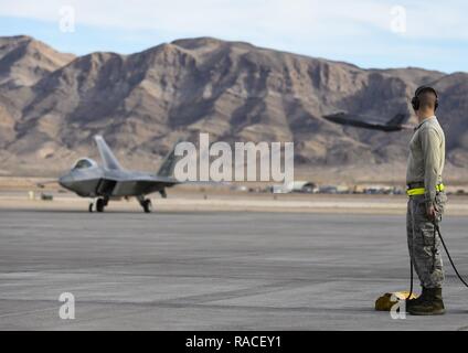 Us Air Force Piloten mit der 1 Aircraft Maintenance Squadron zu Taxi F-22 Raptor an der Nellis Air Force Base, Nev, Feb 18, 2017 vorbereiten. Das Flugzeug an Langley Air Force Base, Virginia, 1. Fighter Wing zugewiesen wird Air Combat Ausbildung Einsätze mit verschiedenen Flugzeugtypen, darunter F-35 Lightning II während Red Flag 17-1 führen. Stockfoto