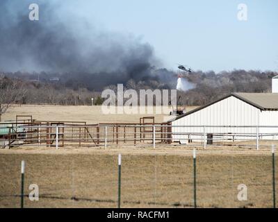 Oklahoma Army Wachposten waren im lokalen Feuerwehrmänner in Edmond zu am 24. Januar. Acht Soldaten auf zwei UH-60 Blackhawk Hubschrauber mit Bambi Eimer flog fast drei Stunden und ließ 30 Eimer, loslassen um 19.800 Liter Wasser auf ein wildes Feuer, dass die Häuser im Bereich verschlungen. Oklahoma's Büro des Notfallmanagements beantragt die Hubschrauber auf Standby wegen der hohen Gefahr von Waldbränden. Ein Hubschrauber um das Ablösen 1, Firma C, 1st Battalion, 169Th Aviation Regiment in Lexington, Oklahoma, und einen Hubschrauber zu Unternehmen C, 1.BATAILLON, 2 zugewiesen Stockfoto