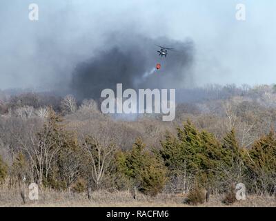 Oklahoma Army Wachposten waren im lokalen Feuerwehrmänner in Edmond zu am 24. Januar. Acht Soldaten auf zwei UH-60 Blackhawk Hubschrauber mit Bambi Eimer flog fast drei Stunden und ließ 30 Eimer, loslassen um 19.800 Liter Wasser auf ein wildes Feuer, dass die Häuser im Bereich verschlungen. Oklahoma's Büro des Notfallmanagements beantragt die Hubschrauber auf Standby wegen der hohen Gefahr von Waldbränden. Ein Hubschrauber um das Ablösen 1, Firma C, 1st Battalion, 169Th Aviation Regiment in Lexington, Oklahoma, und einen Hubschrauber zu Unternehmen C, 1.BATAILLON, 2 zugewiesen Stockfoto