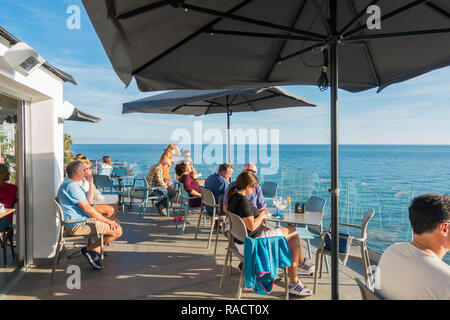 Menschen sitzen Hohe Terrasse mit Blick auf das Mittelmeer, Benalmadena, Andalusien, Spanien. Stockfoto