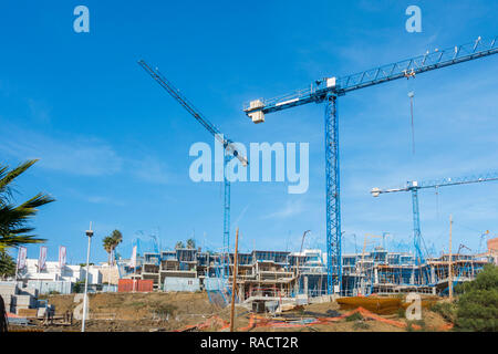 Eine Baustelle mit blauen Krane und unvollendete Gebäude, Wohnung Komplex, Benalmadena, Spanien. Stockfoto