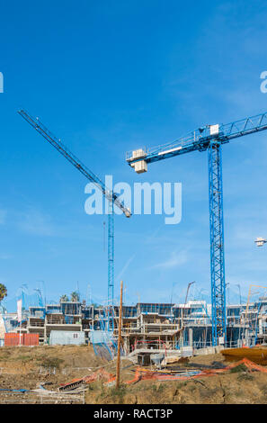 Eine Baustelle mit blauen Krane und unvollendete Gebäude, Wohnung Komplex, Benalmadena, Spanien. Stockfoto