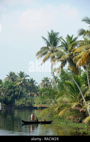 Kerala boatman übersetzende Dorfbewohner über die backwaters in Holz- Einbaum, Kumarakom, Kerala, Indien, Asien Stockfoto