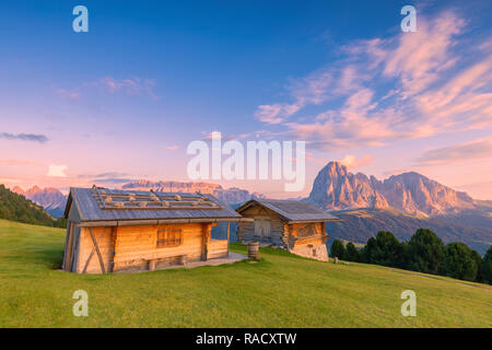 Urige Hütten bei Sonnenuntergang mit Langkofel und Sellagruppe, Grödnertal, Südtirol, Dolomiten, Italien, Europa Stockfoto