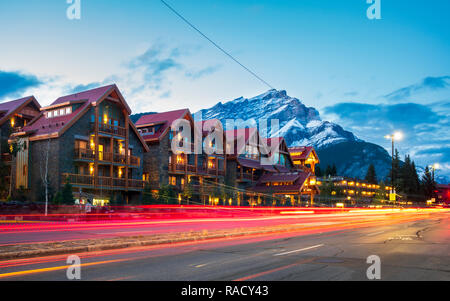 Trail Lichter an der Banff Avenue und Berge im Hintergrund in der Dämmerung, Banff, Banff National Park, Alberta, Kanada, Nordamerika Stockfoto