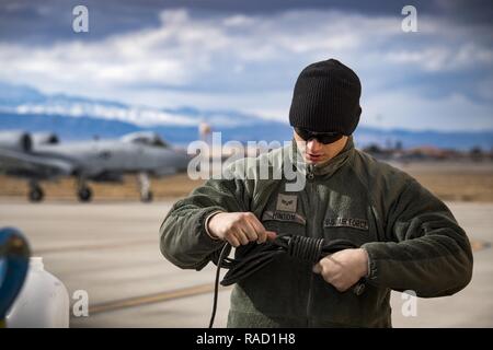 Senior Airman Eric Hinton, 74th Aircraft Maintenance Unit Crew Chief, wickelt die Kommunikation Netzkabel als A-10C Thunderbolt II Taxis für die flightline während der Grünen Flag-West 17-03, 23.01.2017, an der Nellis Air Force Base, Nev GFW ist ein Luft-land Integration Combat Training übung, die 12 A-10 s von Moody Air Force Base, Ga hosted begleitet die Flugzeuge waren 130 Mitarbeiter der Instandhaltung rund um die Uhr zu 18 Einsätzen pro Tag starten. Stockfoto