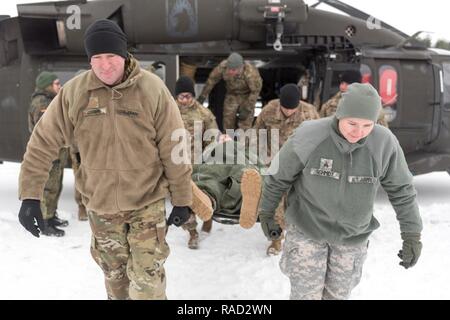 Grafenwöhr, Deutschland - als Teil der Kälte - last Training durch Besatzungsmitglieder von C Unternehmen 1-214 th Allgemeine Unterstützung Aviation Battalion, Maj. Christopher C. Corrie und Sgt. Holly J. Schmidt von der 64th medizinischen Loslösung Veterinärmedizinische Dienste unterstützen, Maj. Linda C. Benavides und Sgt. Erste Klasse David A. Thompson, der 67., OP-Team, führen Sie ein Wurf von Cpt. Aaron J. Vandenbos des 67. Vorwärts Op-Team aus einem UH-60A/L Blackhawk Hubschrauber, Jan. 10, 2017. Stockfoto