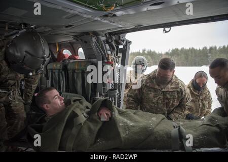 Grafenwöhr, Deutschland - SPC. Nicholas R. Pflug, Entladen von einem UH-60A/L Blackhawk Helicopter, die durch die Kolleginnen und Kollegen des 67., OP-Team, SPC. Brandon M. Morales, Sgt. Heather L. Wiley und SPC. Branden R. Baldwin als Staff Sgt. Nestor A. Genuino und Sgt. Alejandro Arredondo von C Unternehmen 1-214 th Allgemeine Unterstützung Aviation Battalion beobachten, Jan. 10, 2017. Stockfoto