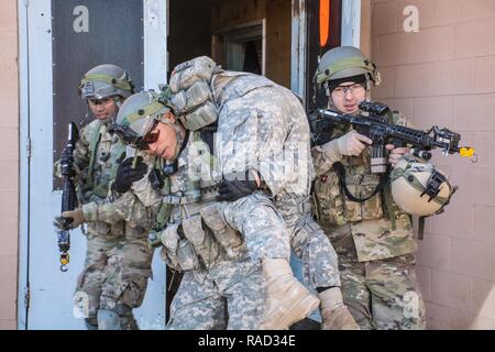 FORT IRWIN, CALIF. - Soldaten aus Assassin's Truppe, 1.Staffel, 11 gepanzerte Kavallerie Regiments bieten Abdeckung für einen verletzten Soldaten zu einem ausgewiesenen HLZ während einer Air Assault Training am Fuldez Ground Control Center in der National Training Center, Jan. 25, 2017 evakuiert. Ziel dieser Mission war es, die Fähigkeit der Truppe komplexe Angriffe durchzuführen und gleichzeitig die Verbesserung der Fähigkeit der Einheit der Beschäftigung von Aviation Ressourcen zu demonstrieren. Stockfoto