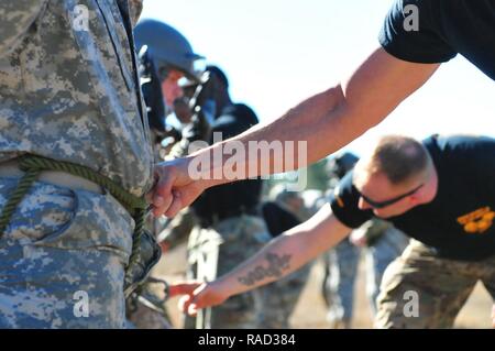 Senior Instrukteure aus dem XVIII Airborne Corps' DeGloppers Air Assault School, Fort Bragg, N.C., Durchführung von Sicherheitskontrollen von abseilen Ausrüstung von Studenten am 31.01.25, 2017, gebunden, auf die US-Armee Simmons Flugplatz. Auf dem Display ist eine Verpflichtung für die Sicherheit, die Dozenten überprüfen die Schüler, bevor sie von einem UH-60 Black Hawk Hubschrauber 100 Fuß über dem Boden während der Phase drei der Air Assault Training Schule abseilen. Stockfoto