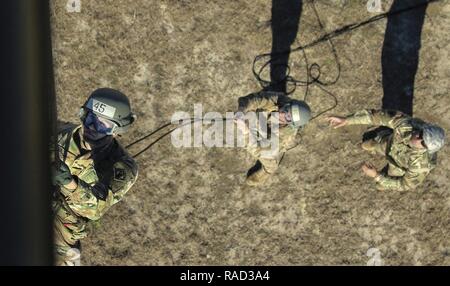 XVIII Airborne Corps DeGlopper Air Assault School Kursteilnehmer rappels aus einem UH-60 Black Hawk Hubschrauber in Fort Bragg, N.C., Jan. 25, 2017. Der Kurs erstreckt sich über 10 Tage soll Soldaten im Einsatz von Schleuder- für Air Assault Operationen zu trainieren. Stockfoto