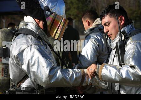 Cpl. Noah Rios passt Sgt. Maj Charles Metzgers Gang während einer Live Fire Training Event auf der Marine Corps Air Station New River, N.C., Jan. 19, 2017. Die Ausbildung benutzt Propan und Rohrleitungen Brände auf dem Innen und Außen, um ein Flugzeug zu simulieren. Rios ist ein rescueman mit Flugzeugen Rescue Marine Corps Air Station New River's Brandbekämpfung Division. Metzger ist der Air Station Sergeant Major. Stockfoto
