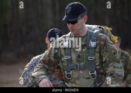 Us Army 1st Lieutenant Byron Denman, Jumpmaster, 412 zivilen Angelegenheiten Bataillon Hilfe Erste Schritte mit auf die T-11 Fallschirm im Norden Auxiliary Airfield in Orangeburg, S.C. Jan. 26, 2017. Der 360 zivilen Angelegenheiten der Feuerwehr durchgeführten Operation Anvil diese Airborne Sprung für Jumpmasters für die Durchführung ihrer Aufgaben und für die Jumper Währung für Jump Status aufrecht zu erhalten. Stockfoto