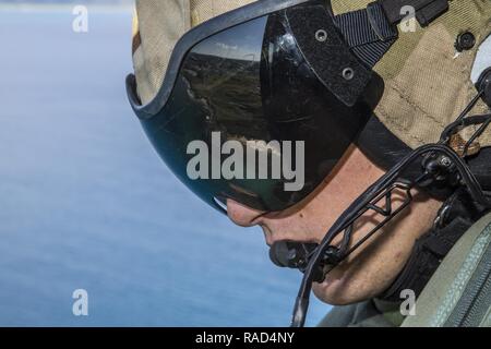 Us Marine Corps Cpl. Jakob E. Beedle, Ein UH-1Y Hubschrauber Crew Chief mit Marine Light Attack Helicopter Squadron 267, 1 Marine Flugzeugflügel, III Marine Expeditionary Force, Scans der Horizont bei einem Flug über die umliegenden Gewässer von Okinawa, Japan, Jan. 27, 2017. UH-1Y Huey Hubschrauber transportiert Generalmajor Craig Timberlake, Kommandierender General, 3rd Marine Division, die Jungle Warfare Training Center auf Lager Gonsalves, Okinawa, Japan. Stockfoto