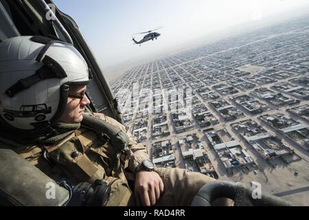 Naval Aircrewman (Hubschrauber) 2. Klasse Keaton Gish, Ladegeräte Hubschrauber Meer Combat Squadron (HSC) 26, den Horizont für Kontakte von einem MH-60 Seahawks über Kuwait, Jan. 12, 2017 Scans zugeordnet. HSC-26 ist ein Vorwärts bereitgestellt Seestreitkräfte Asset zum Kommandanten angebracht, Task Force 53 Bekämpfung von Logistik und Suche und Rettung Fähigkeiten in den gesamten USA 5 Flotte Bereich der Operationen zur Verfügung zu stellen. Stockfoto