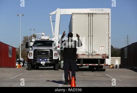 Ein Offizier mit der US-amerikanischen Zoll- und Grenzschutzbehörden von Field Operations Guides ein CBP-x-ray Inspektion Fahrzeug bei Kontrollen von Nutzfahrzeugen, wie sie an NRG Stadion in Vorbereitung auf die Super Bowl 51 in Houston, Texas, Jan. 30, 2017 ankommen. Us-amerikanischen Zoll- und Grenzschutz Stockfoto