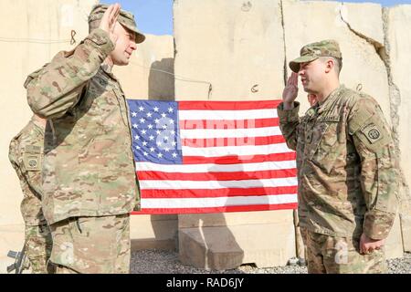 Oberstleutnant John Hawbaker, Kommandant der 1. Staffel, 73 Cavalry Regiment, 2nd Brigade Combat Team, 82nd Airborne Division, Fragen nach dem Eid des reenlistment zu Sgt. Patrick R. Bradford, ein infanterist, nach seiner dreijährigen reenlistment bei Qayyarah West, Irak, Jan. 26, 2017. Zur Unterstützung der Operation inhärenten lösen, die 2 BCT eingesetzt, 82. Abn. Div. ermöglicht, ihre irakische Sicherheitskräfte, die Partner durch den beraten und unterstützen die Mission, die die Planung, Erfassung und Analyse von Intelligenz, Kraft und Präzision Brände die militärische Niederlage der ISIL zu erreichen. Stockfoto