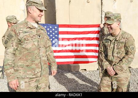 Oberstleutnant John Hawbaker, Kommandant der 1. Staffel, 73 Cavalry Regiment, 2nd Brigade Combat Team, 82nd Airborne Division, gratuliert Sgt. Patrick R. Bradford, ein infanterist, nach seiner dreijährigen reenlistment bei Qayyarah West, Irak, Jan. 26, 2017. Zur Unterstützung der Operation inhärenten lösen, die 2 BCT eingesetzt, 82. Abn. Div. ermöglicht, ihre irakische Sicherheitskräfte, die Partner durch den beraten und unterstützen die Mission, die die Planung, Erfassung und Analyse von Intelligenz, Kraft und Präzision Brände die militärische Niederlage der ISIL zu erreichen. Stockfoto