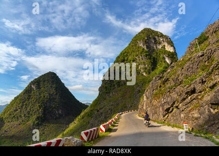 Eine Frau, ein Motorrad, eine schmale Bergstraße. Ha Giang Loop, Provinz Ha Giang, Vietnam, Asien Stockfoto