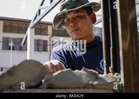 Ein Royal Thai Army Soldat mit Mobile Development unit 52, gilt konkret an einer Wand bei Ban Nong Mi Schule, Provinz Buri Ram, Thailand, während der übung Cobra Gold, Feb 1, 2017. Cobra Gold, in seiner 36. Iteration, konzentriert sich auf die humanitären Civic action, Engagement für die Gemeinschaft, und ärztlichen Tätigkeiten die Bedürfnisse und das humanitäre Interesse der Zivilbevölkerung in der Region zu unterstützen. Stockfoto