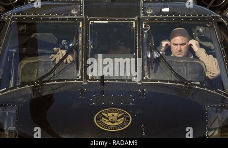 Ein Verbot Agent mit der US-amerikanischen Zoll- und Grenzschutzbehörden, Luft und Marine Operations, bereitet das Cockpit des UH-60 Black Hawk Hubschrauber vor einem Flug in der Luftraum Sicherheit für Super Bowl LI, in Dallas, Texas, Feb 1, 2017. Einheiten mit Luft und Marine Operations und Büro der Feldeinsätze teamed oben mit der Civil Air Patrol ein Luft-zu-Luft mit zwei AMO UH-60 Black Hawk Hubschraubern abfangen und zwei C-550 Citation Jets auf die Spur einer simulierten Einfall in eingeschränkten Luftraum zu üben. Us-amerikanischen Zoll- und Grenzschutz Stockfoto