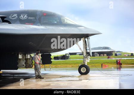Us Air Force Mannschaft Leiter der 509th Aircraft Maintenance Squadron schirmt sich vor dem Regen unter einem B-2 Spirit bei Andersen Air Force Base, Guam, Jan. 12, 2017 zugeordnet. In der Nähe von 200Flieger und drei B-2s bereitgestellt von whiteman Air Force Base, Calif., und Barksdale Air Force Base, La., lokale sorties und Regional Training zu leiten und mit regionalen Verbündeten zur Unterstützung der Bomber Qualitätssicherung und Abschreckung Missionen integrieren. Stockfoto