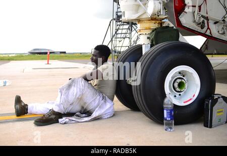 Us Air Force Staff Sgt. Elia Fleming, ein Mannschaft Leiter der 509th Aircraft Maintenance Squadron zugeordnet, sitzen und eine Minute dauert, unter einem US Air Force B-2 Spirit Flugzeuge bei Andersen Air Force Base, Guam, Jan. 17, 2017 zu entspannen. In der Nähe von 200Flieger und drei B-2s bereitgestellt von whiteman Air Force Base, Calif., und Barksdale Air Force Base, La., zur Unterstützung der US-Strategic Command Bomber Qualitätssicherung und Abschreckung Missionen. USSTRATCOM Einheiten führen regelmäßig Schulungen mit und zur Unterstützung der geografischen Kämpfer Befehle. USSTRATCOM, durch seine globale Streik Vermögenswerte, hilft bei der Aufrechterhaltung der globalen Stabi Stockfoto