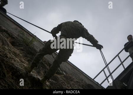 Ein Marine mit Fox Company, Bataillon Landung Team, 2nd Battalion, 5th Marines, 31 Marine Expeditionary Unit, rappels auf einer Klippe an der Jungle Warfare Training Center, Camp Gonsalves, Okinawa, Japan, Jan. 24, 2017. JWTC entlarvt Marines training Situationen und Umgebungen der Indo-Asia-Pazifik-Region, die Einsatzbereitschaft unterstützen und vorwärts eingesetzten Fähigkeiten verbessern. Wie das Marine Corps' nur kontinuierlich vorwärts eingesetzt, Luft - Boden des 31 Marine Expeditionary Unit-Logistik Team bietet eine flexible Kraft, bereit, eine breite Palette der militärischen Operation durchzuführen Stockfoto