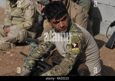 Ein peshmerga Soldat hört nach der Überprüfung der Maßnahmen Kommentare während urban Operations Training in der Nähe von Erbil, Irak. Niederländische und norwegische Soldaten, Teil der Kurdistan Training Coordination Center, beaufsichtigte Ausbildung ist der Tag, den der einzelnen Bewegung Techniken enthalten, Counter IED und Einlasskontrolle verfahren. Die KTCC ist eine multi-nationale Koalition für die Ausbildung, Beratung und Unterstützung der kurdischen Truppen ISIL im Irak zu besiegen. Stockfoto