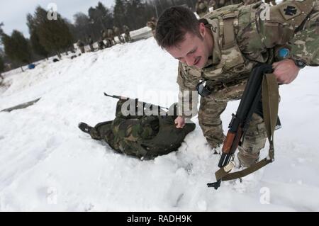 Sgt. Carey Bennett, ein Mitglied der Bravo Company, 1st Battalion, 179Th Infantry Regiment, 45th Infantry Brigade Combat Team und ein Bewohner von Oklahoma City, schleppt eine ukrainische Soldaten durch Schnee zu demonstrieren Evakuieren ein Unfall während eines ukrainischen-led-Bekämpfung der Erste Hilfe Kurs an der internationalen Friedenssicherung und Security Center, in der Nähe der Yavoriv, Ukraine, am 1. Der Unfall Evakuierung Demonstration war Teil der ersten Ukrainischen-led-Bekämpfung der Erste Hilfe Kurs wo Combat Training Center Personal unterrichtet Soldaten der 1. der ukrainischen Armee Bataillon, 28 mechanisierte Infanterie Brigade wie zu behandeln Stockfoto