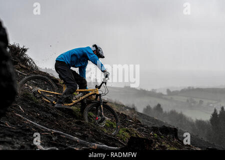 Ein Mountainbike sendet Schlamm Spritzen in die Luft, eine Spur an einem regnerischen Winter in South Wales. Stockfoto