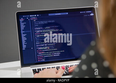 Frau Programmer mit Tasse Kaffee Arbeiten am Laptop im PHP-Code im Büro Stockfoto