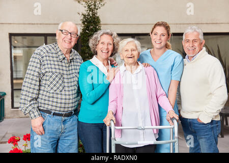 Gruppe von Senioren als Freunde lachen gerne mit altenpflegerin im Ruhestand home Stockfoto