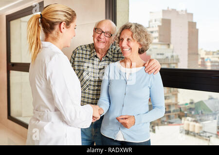 Arzt Händeschütteln mit Senior Paar in einem Krankenhaus oder Pflegeheim Stockfoto