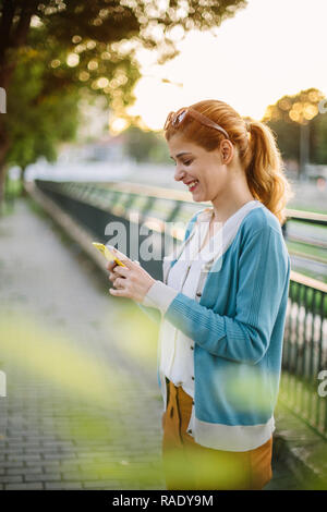 Junge Frau sms Nachricht auf smart phone Stockfoto