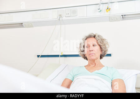 Die Frau als ein unzufriedener Patient liegt im Krankenhausbett und schaut besorgt Stockfoto